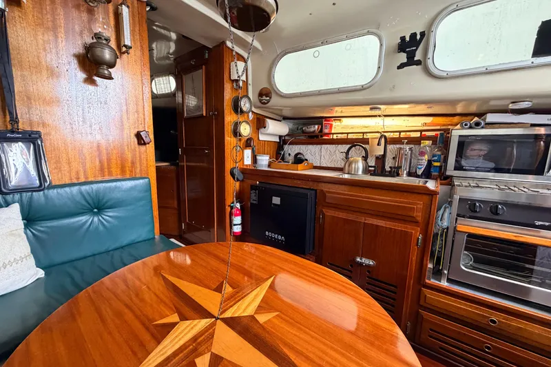 Slide: The Image of Interior of a 1964 Columbia 33 sailboat with wooden furnishings and kitchen amenities. - 33