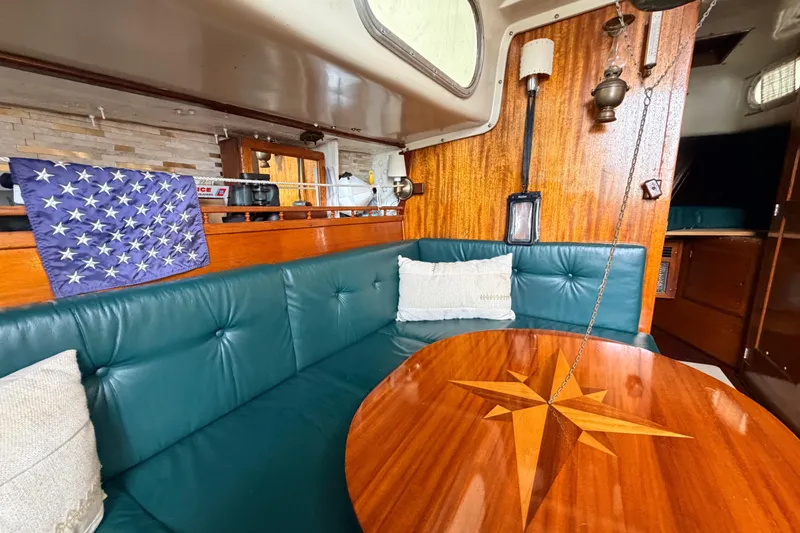 Slide: The Image of Interior of a 1964 Columbia 33 sailboat with teal seating and wooden table. - 34