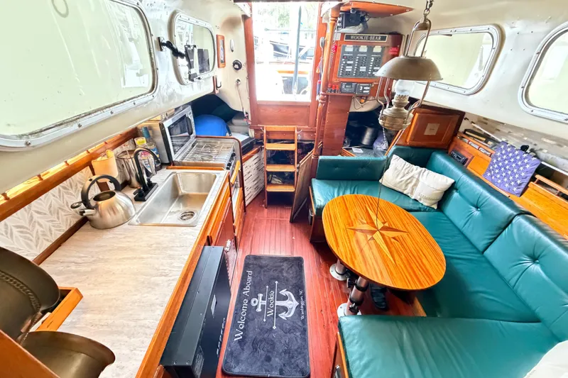 Slide: The Image of Interior of a 1964 Columbia 33 sailboat with cozy seating and kitchenette. - 36