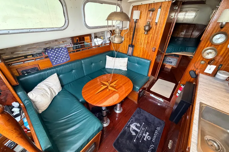 Slide: The Image of Interior of a 1964 Columbia 33 sailboat with green seating and wooden accents. - 37