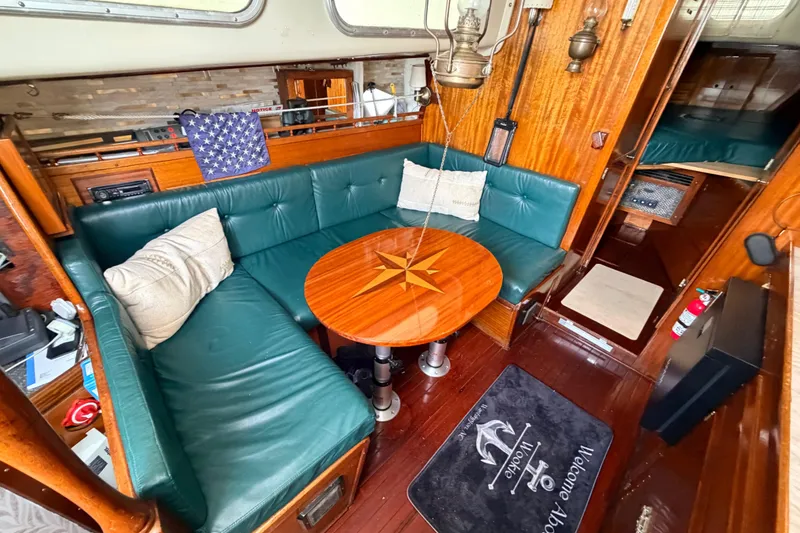 Slide: The Image of 1964 Columbia 33 yacht interior with green seating, wooden table, and nautical decor. - 38