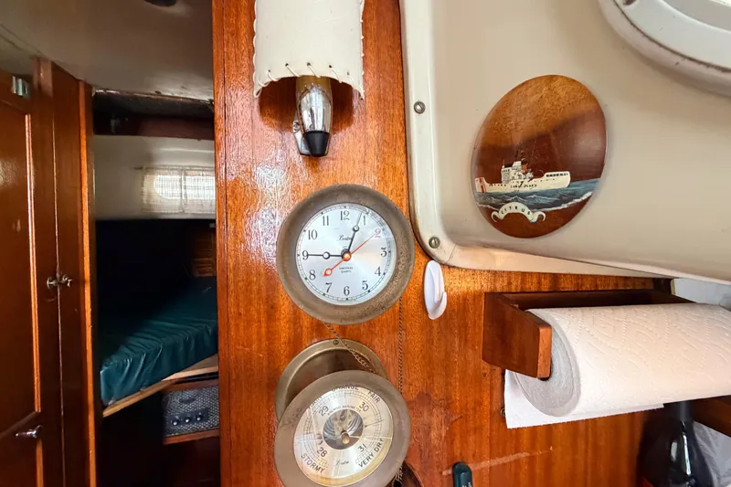 Slide: The Image of Interior of a 1964 Columbia 33 sailboat with clock, barometer, and nautical decor. - 39