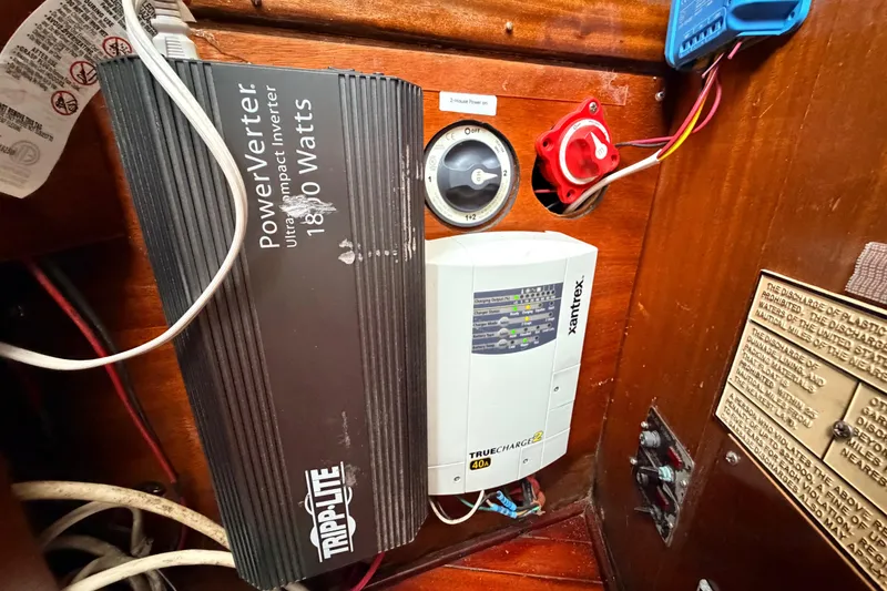 Slide: The Image of Electrical setup inside a 1964 Columbia 33 boat, featuring a power inverter and charger. - 41