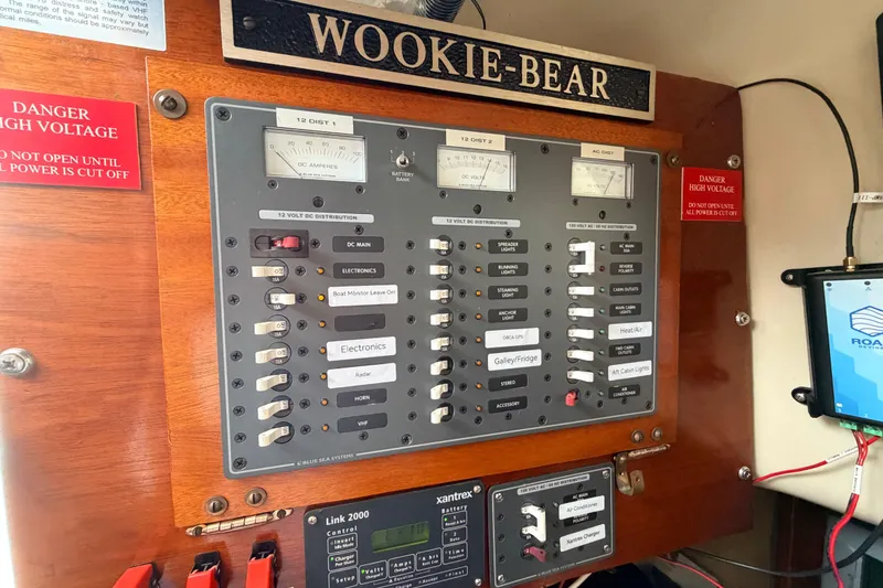 Slide: The Image of Electrical panel on 1964 Columbia 33 sailboat, labeled "Wookie-Bear," with high voltage warning. - 48