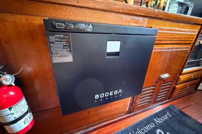 Slide: The Image of Black Bodega cooler installed in a 1964 Columbia 33 boat interior with wooden cabinetry. - 50