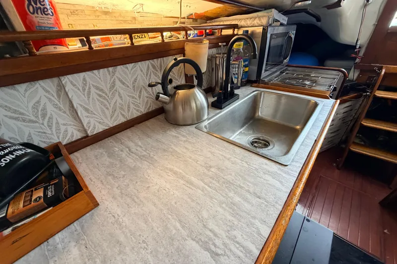 Slide: The Image of 1964 Columbia 33 yacht kitchen with sink, kettle, and stove. - 53