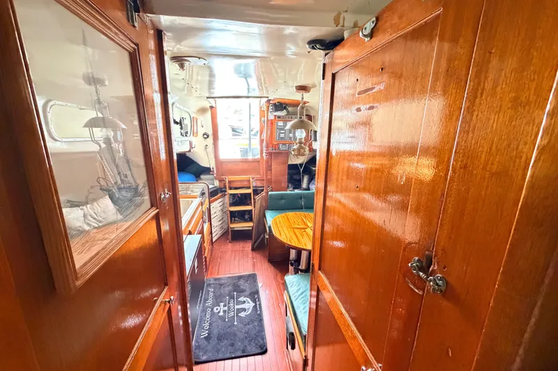 Slide: The Image of Interior of a 1964 Columbia 33 sailboat with wooden furnishings and cozy seating area. - 61