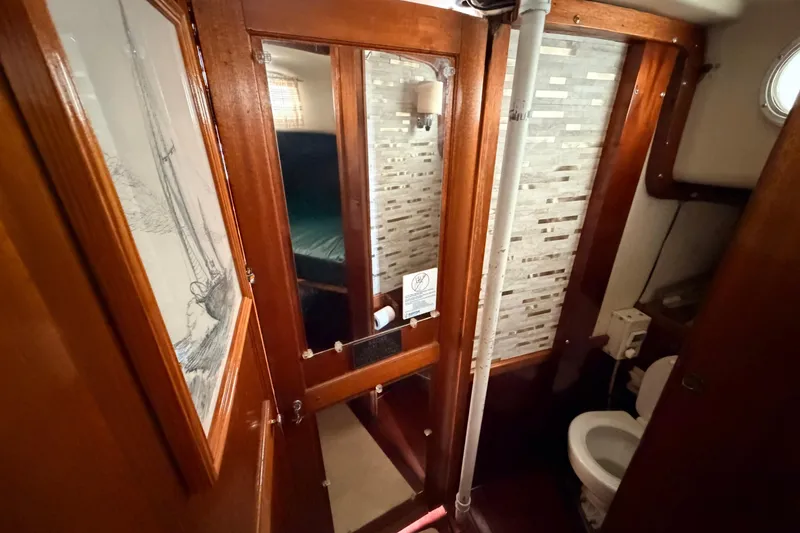 Slide: The Image of Interior of a 1964 Columbia 33 sailboat featuring a compact bathroom with wooden accents. - 62