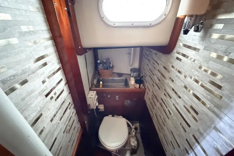 Slide: The Image of Compact bathroom in a 1964 Columbia 33 sailboat with modern tile walls and a small sink. - 65