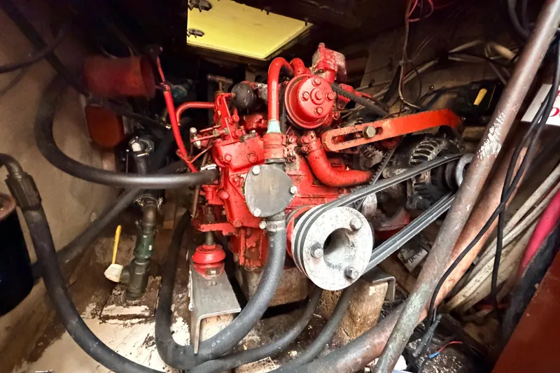 Slide: The Image of Engine compartment of a 1964 Columbia 33 sailboat, featuring a red marine engine. - 67