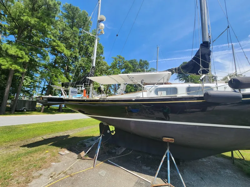 Slide: The Image of 1964 Columbia 33 sailboat on dry dock with trees and blue sky in the background. - 7