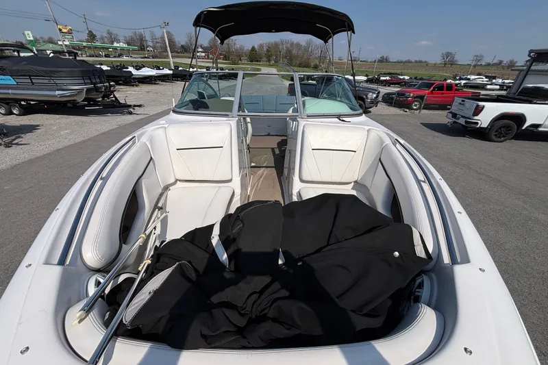 Slide: The Image of 2008 Four Winns H260 RS boat with white seating and black cover, parked outdoors. - 5