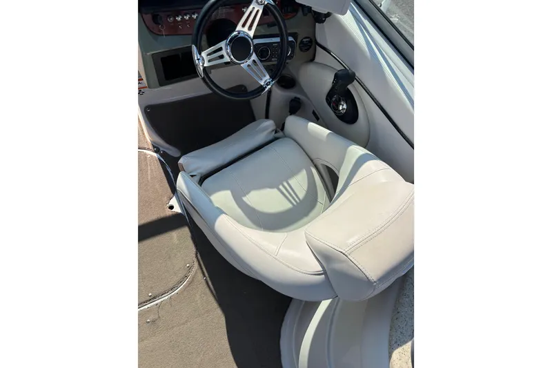 Slide: The Image of 2008 Four Winns H260 RS boat cockpit with steering wheel and beige seating. - 8
