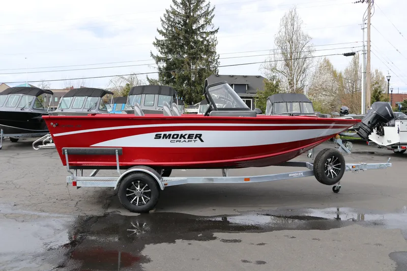 The Image of 2026 Smoker Craft Ultima 182 boat in red on a trailer, parked outdoors. - 0