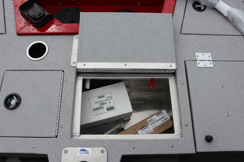 Slide: The Image of Storage compartment on 2026 Smoker Craft Ultima 182 boat, containing boxes and equipment. - 13