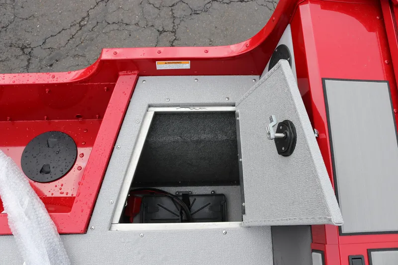 Slide: The Image of Open storage compartment on 2026 Smoker Craft Ultima 182 boat, featuring red and gray design. - 14
