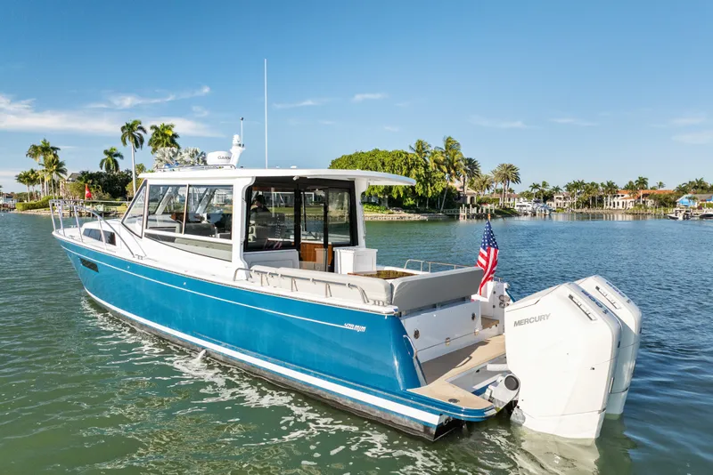 Slide: The Image of MJM 47R 2026 yacht on calm water with palm trees in the background. - 3