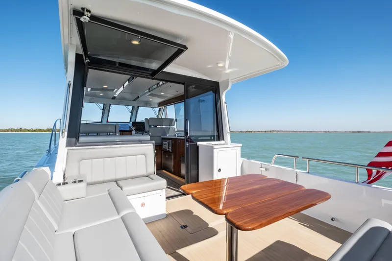 Slide: The Image of Luxurious 2026 MJM 47 R yacht interior with elegant seating and wooden table on open deck. - 35