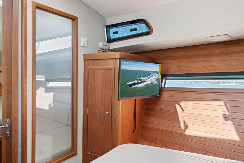 Slide: The Image of Interior of 2026 MJM 47 R yacht with wood paneling and mounted TV. - 25