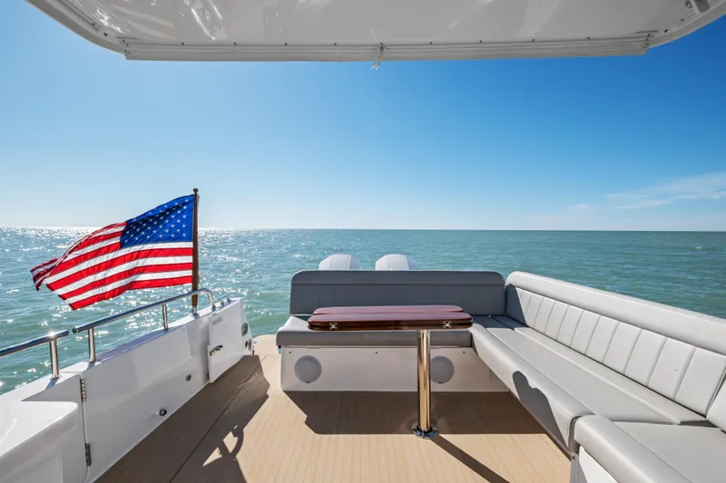 Slide: The Image of Luxury MJM 47 R yacht deck with American flag, ocean view, and seating area, 2026 model. - 39