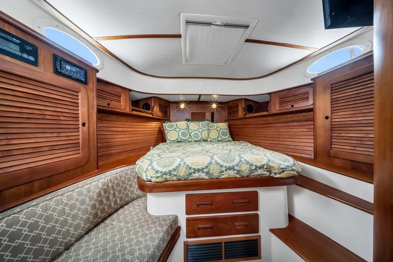 Slide: The Image of Luxurious cabin interior of 2013 Hinckley Picnic Boat 37 MKIII with wood paneling and cozy bedding. - 18