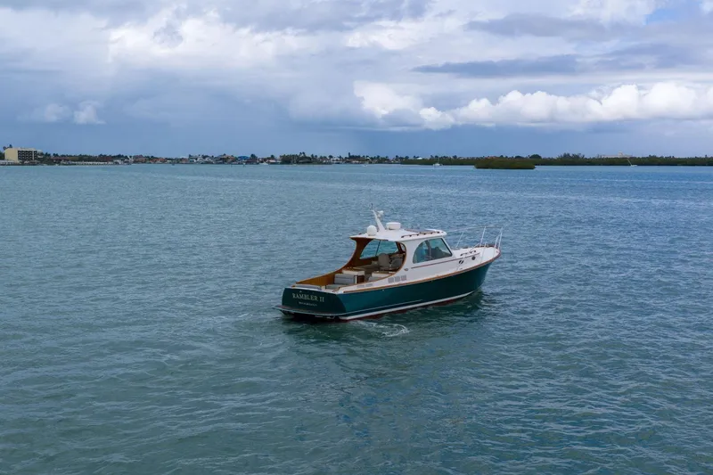Slide: The Image of 2013 Hinckley Picnic Boat 37 MKIII cruising on open water under cloudy skies. - 2
