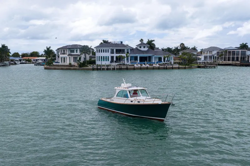 Slide: The Image of 2013 Hinckley Picnic Boat 37 MKIII cruising near waterfront homes. - 3