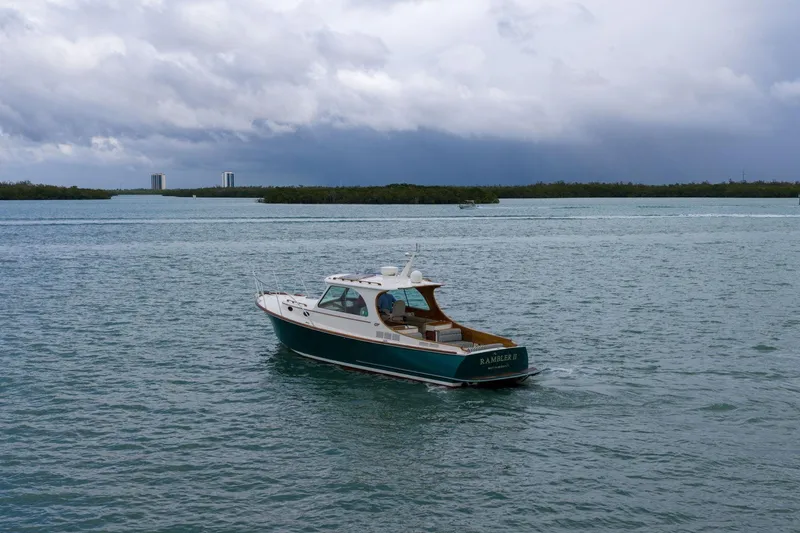 Slide: The Image of 2013 Hinckley Picnic Boat 37 MKIII cruising on a calm, scenic waterway. - 6