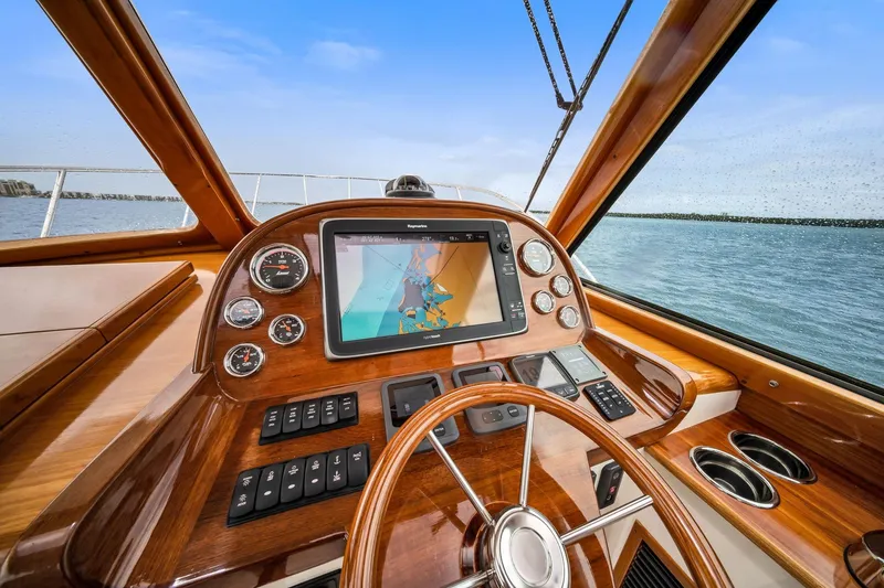 Slide: The Image of Helm of 2013 Hinckley Picnic Boat 37 MKIII with navigation display and wooden dashboard. - 8