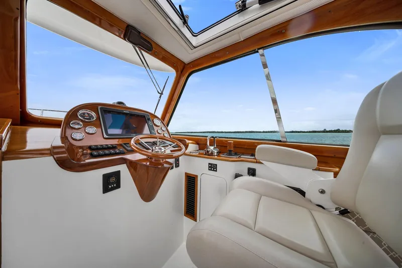 Slide: The Image of Helm of 2013 Hinckley Picnic Boat 37 MKIII with luxurious seating and navigation controls. - 9