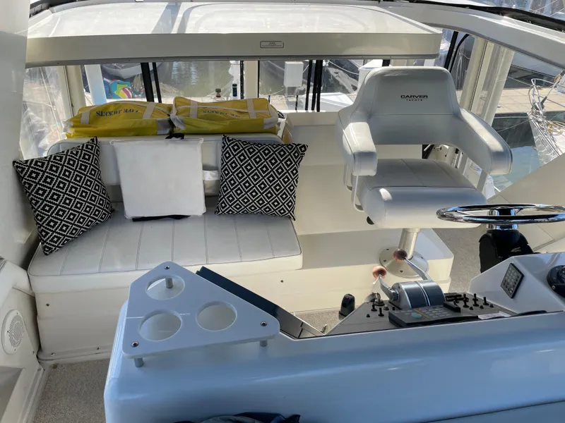 Slide: The Image of 1998 Carver 445 Aft Cabin Motor Yacht helm with seating and control panel. - 17