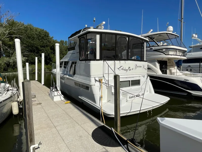 Slide: The Image of 1998 Carver 445 Aft Cabin Motor Yacht docked at marina under clear blue sky. - 4