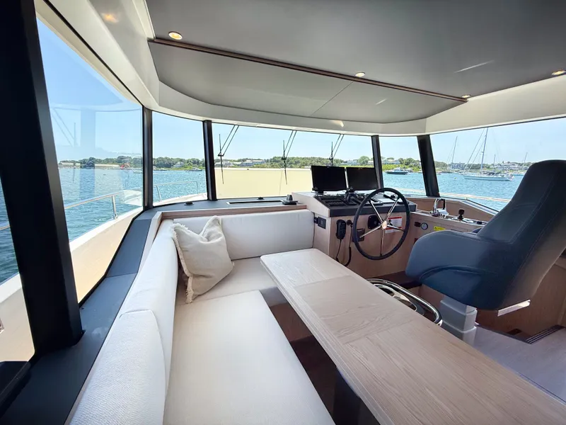 Slide: The Image of Interior of 2026 Beneteau Swift Trawler 54, featuring helm, seating, and panoramic windows. - 10