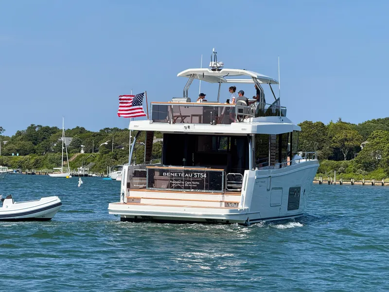 Slide: The Image of 2026 Beneteau Swift Trawler 54 cruising on a sunny day with American flag. - 3