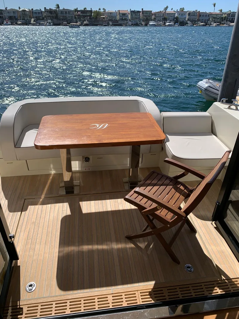 Slide: The Image of 2016 Beneteau Monte Carlo 5 yacht with deck furniture by the water. - 14