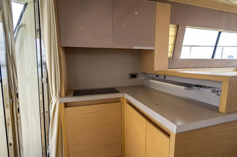 Slide: The Image of Modern kitchen interior on 2016 Beneteau Monte Carlo 5 yacht, featuring sleek cabinetry and countertop. - 20