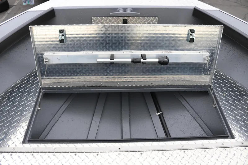Slide: The Image of Open storage compartment on 2026 Alumaweld Super Vee Pro 23 boat with diamond plate flooring. - 12