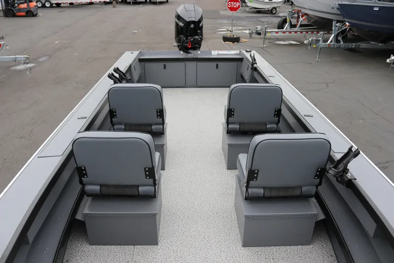 Slide: The Image of 2026 Alumaweld Super Vee Pro 23 boat interior with four gray seats and motor. - 15