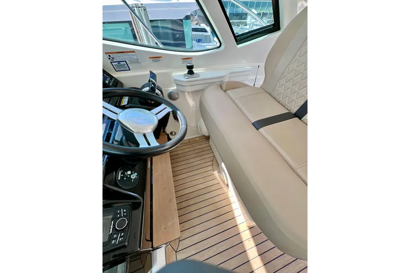 Slide: The Image of Interior of 2017 Sea Ray Sundancer 350 Coupe with steering wheel and beige seating. - 114