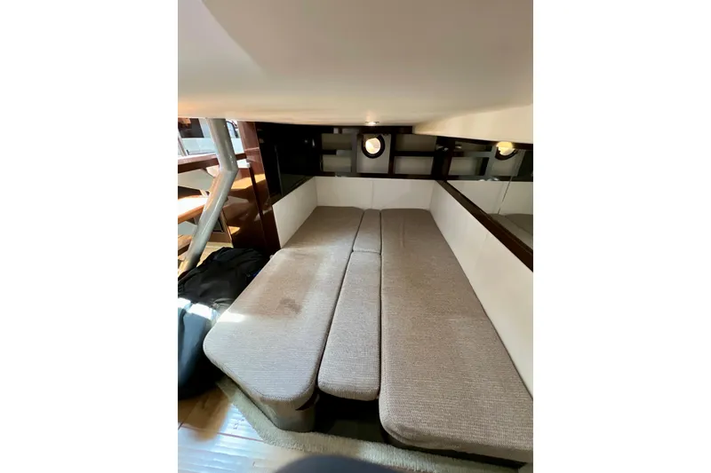 Slide: The Image of Interior cabin of 2017 Sea Ray Sundancer 350 Coupe with beige seating and porthole windows. - 115