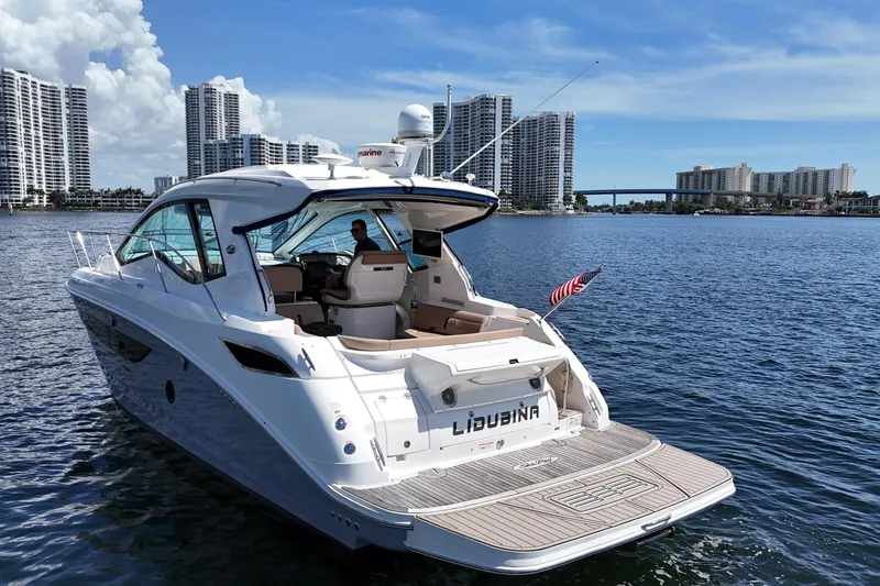 Slide: The Image of 2017 Sea Ray Sundancer 350 Coupe yacht cruising near city skyline. - 13