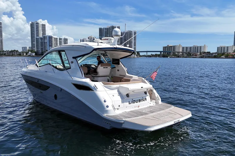 Slide: The Image of 2017 Sea Ray Sundancer 350 Coupe yacht on water, city skyline in background. - 14
