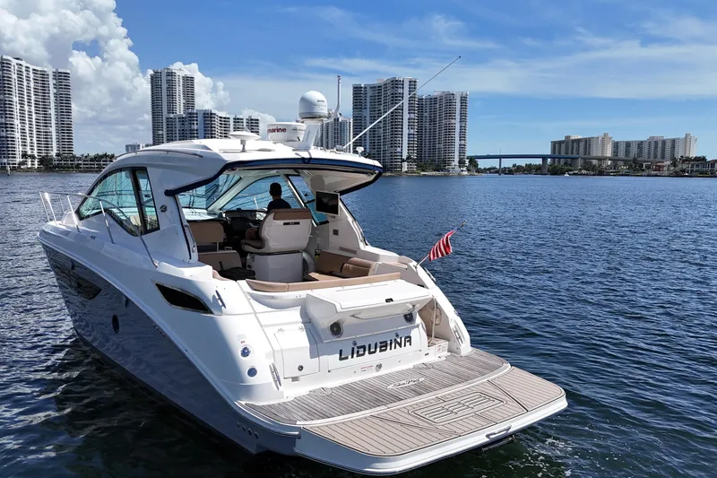 Slide: The Image of 2017 Sea Ray Sundancer 350 Coupe cruising near city skyline on a sunny day. - 16