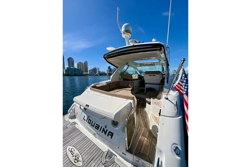 Slide: The Image of 2017 Sea Ray Sundancer 350 Coupe yacht docked with city skyline backdrop. - 17