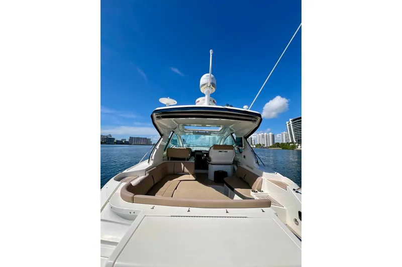 Slide: The Image of 2017 Sea Ray Sundancer 350 Coupe yacht with spacious deck and seating, under clear blue sky. - 22