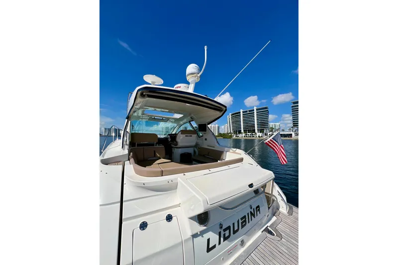 Slide: The Image of 2017 Sea Ray Sundancer 350 Coupe docked, featuring spacious deck and American flag. - 25