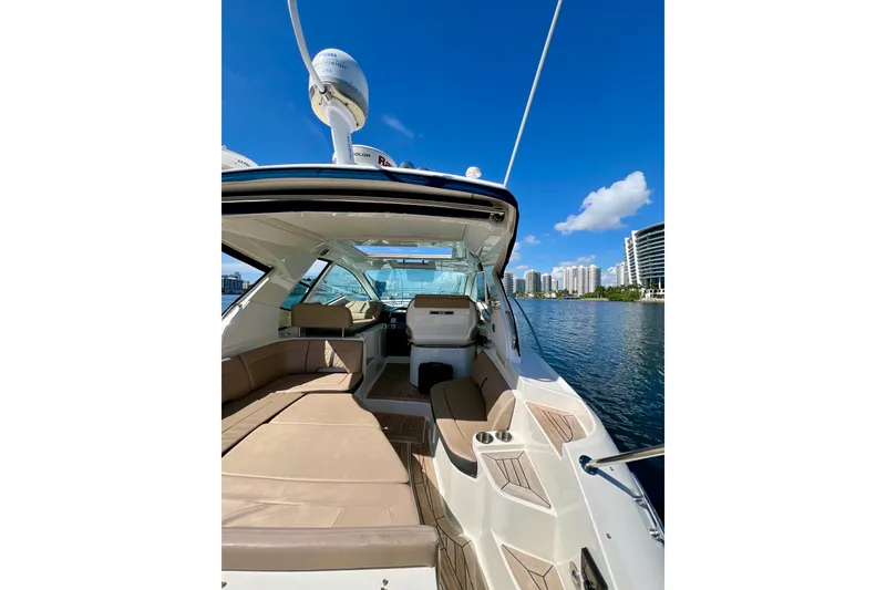 Slide: The Image of 2017 Sea Ray Sundancer 350 Coupe on water, showcasing luxurious interior and city skyline. - 26