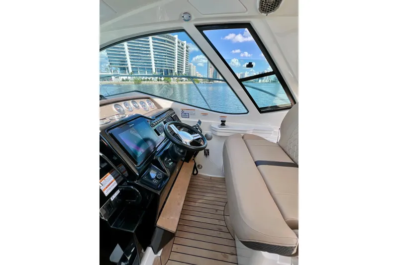 Slide: The Image of Interior view of 2017 Sea Ray Sundancer 350 Coupe with modern dashboard and waterfront scenery. - 41