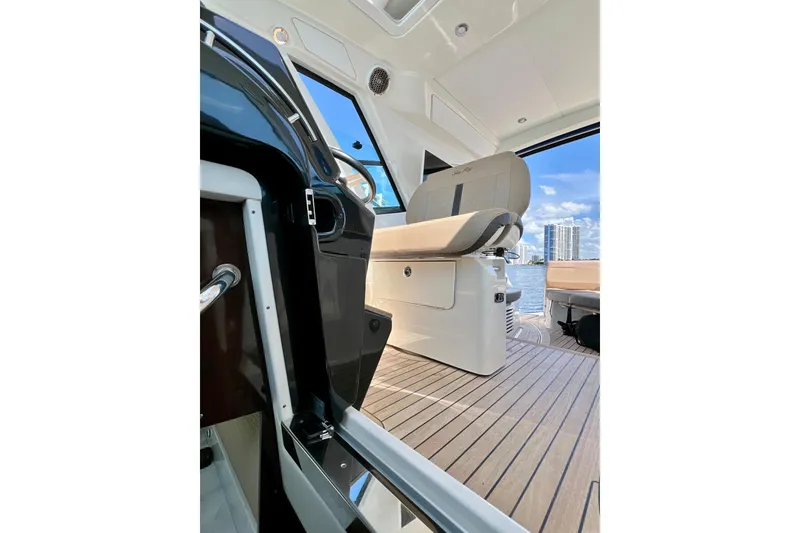 Slide: The Image of 2017 Sea Ray Sundancer 350 Coupe interior with helm seat and waterfront view. - 48