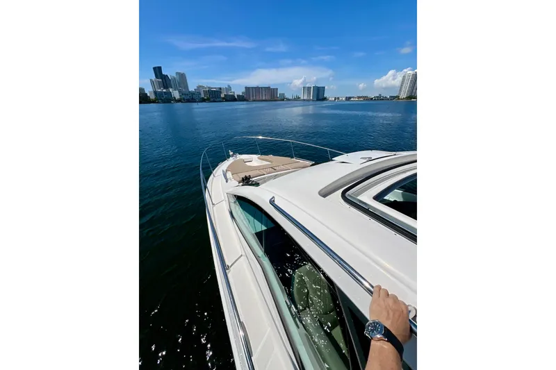 Slide: The Image of 2017 Sea Ray Sundancer 350 Coupe cruising on a sunny day with city skyline views. - 58